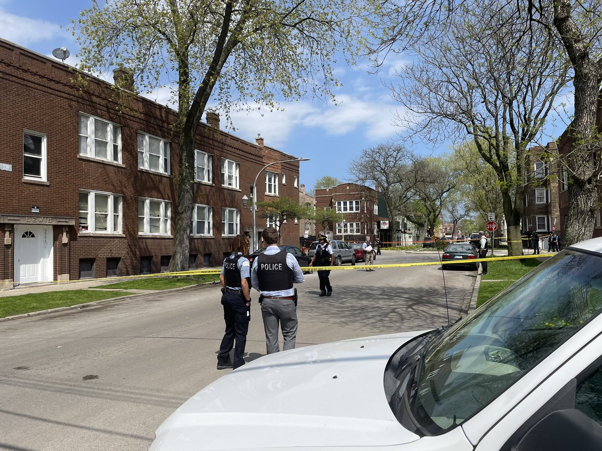 Dozens of evidence markers have been placed at Springfield and Thomas as Chicago police officers investigate. Blood and shattered glass can also be seen on the sidewalk