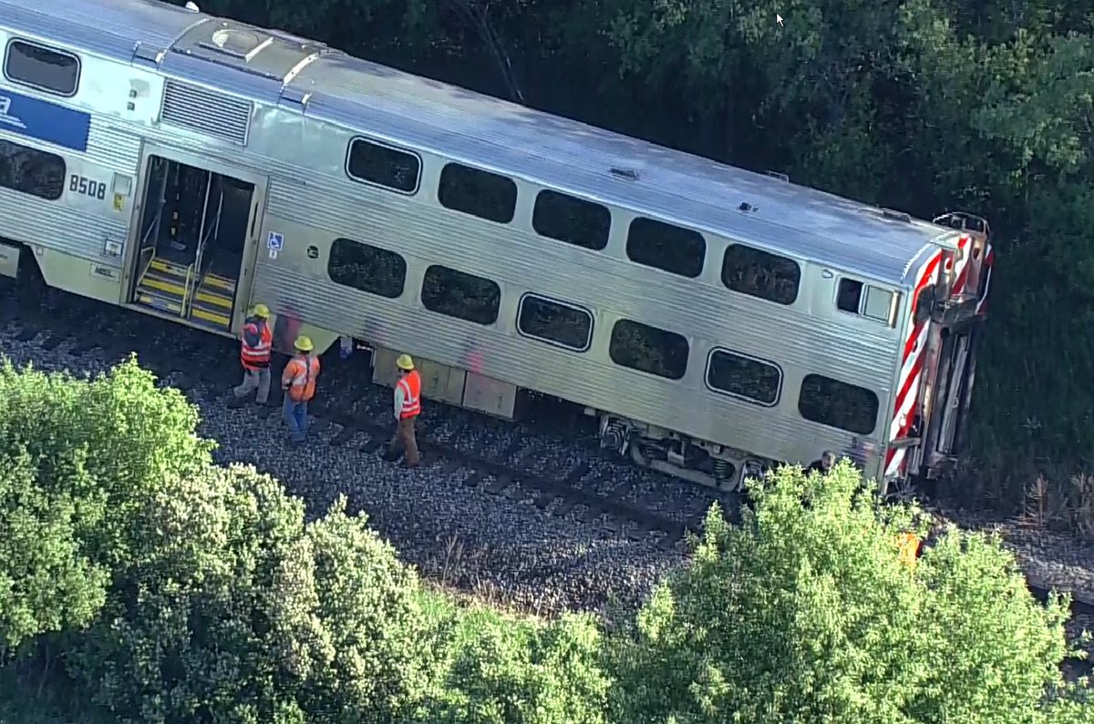 Grayslake - Metra MD N train hit dump truck near 120/HainsevilleRd.   Front car of train has derailed.We saw one passenger carried off on a stretcher.   MDN trains stopped both directions. No crossing gates at this crossing