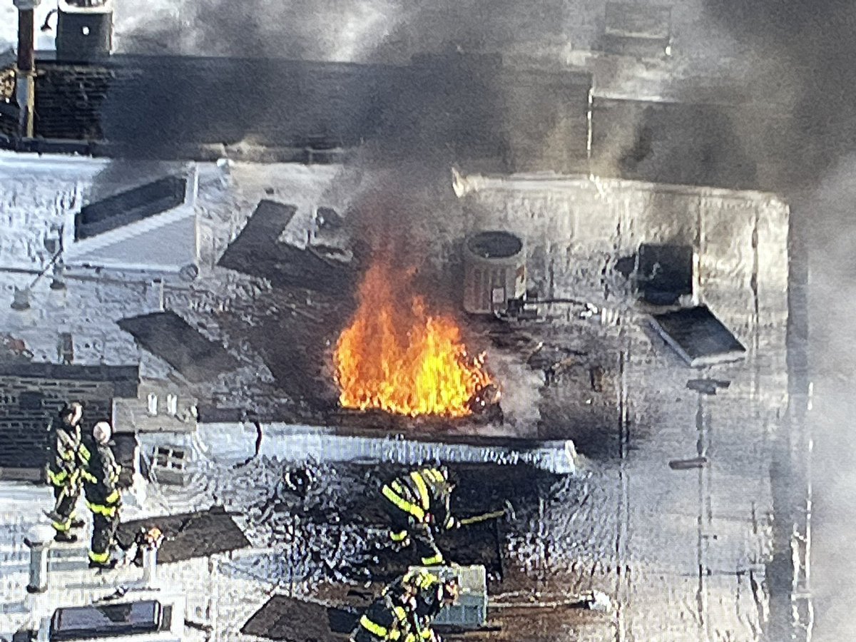 Flames visible through a ventilation hole cut by firefighters in the roof of 3523 N Sheffield. Interior attack should knock down the fire as companies are working their way to the seat of the fire.