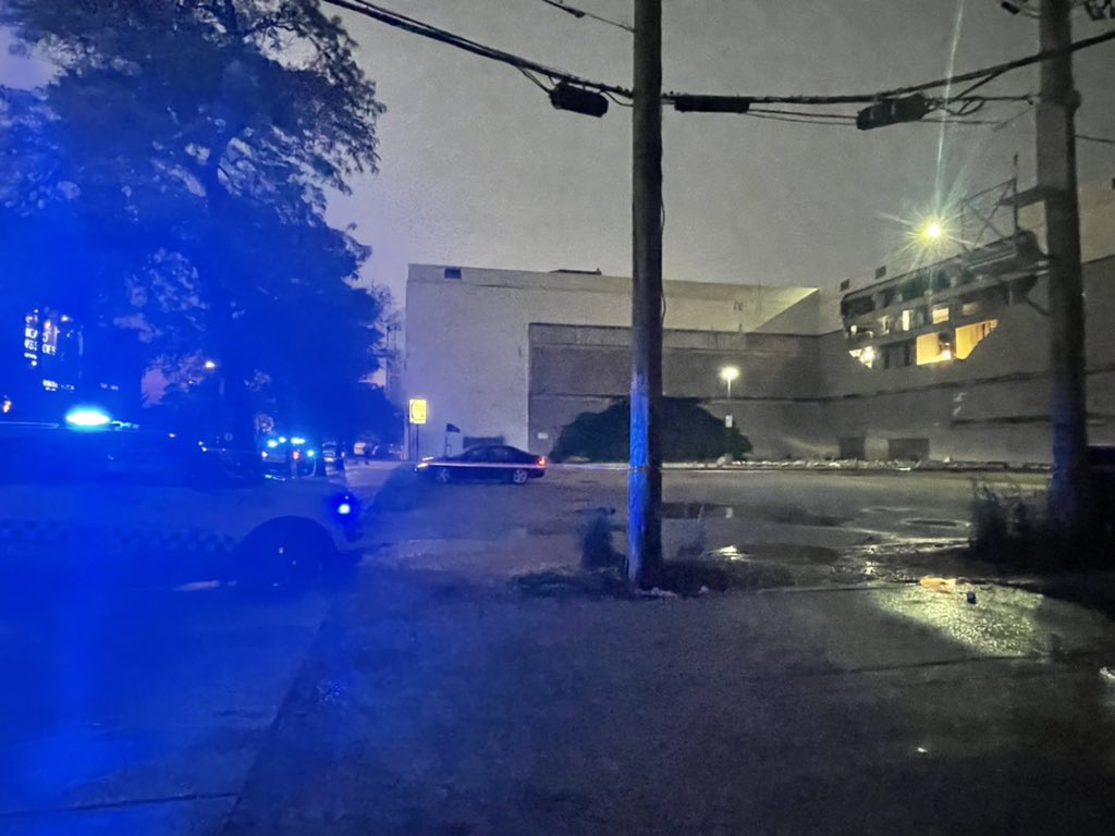 Chicago Police and bystanders stand near the 900 block of west Weed street where a wall partially collapsed at a car dealership.  